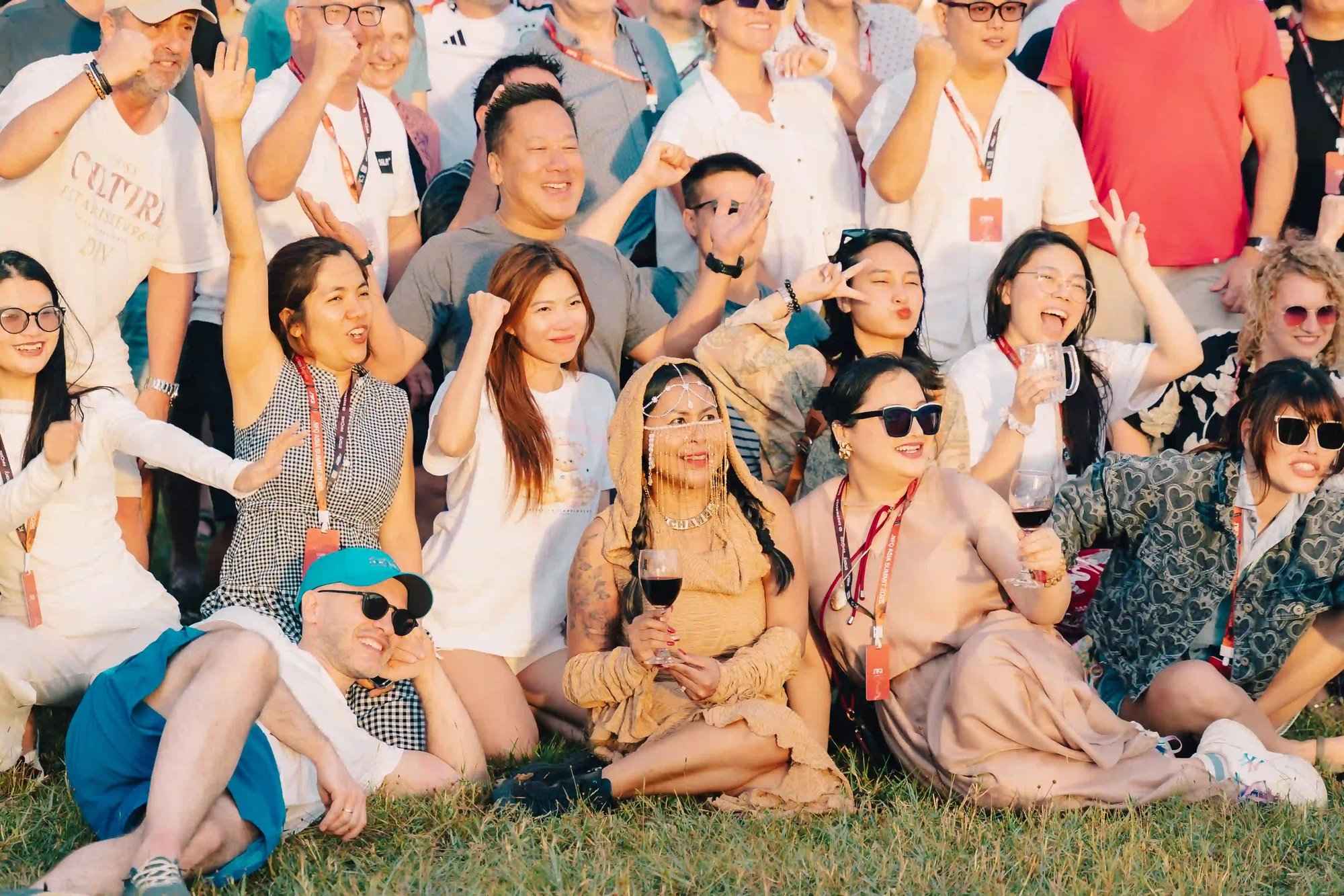 Group of people smiling and posing together outdoors at a sunny event.