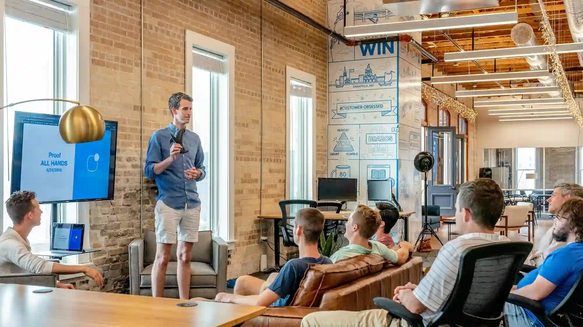 Speaker presenting to a group in a modern office, representing leadership development training.